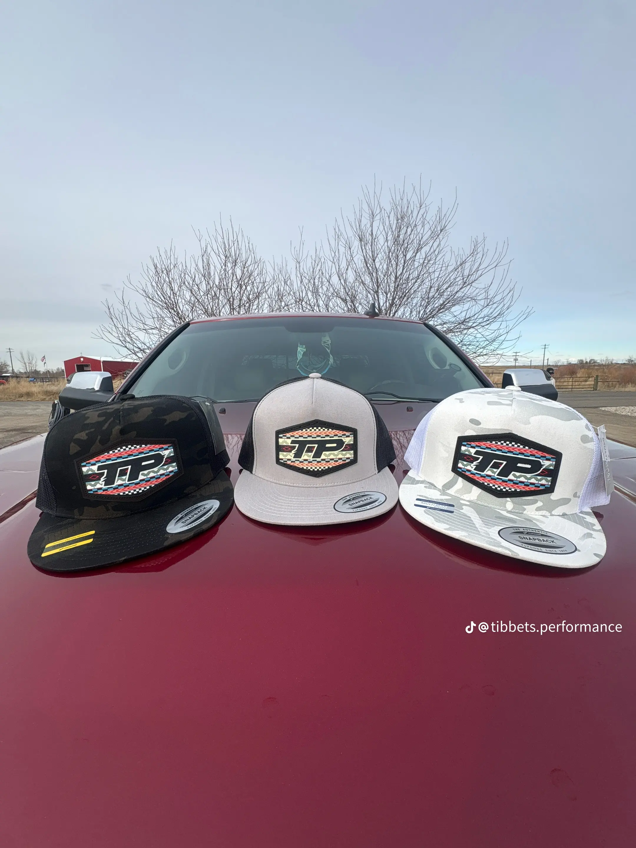 Three Tibbets Performance hats in black, gray, and white