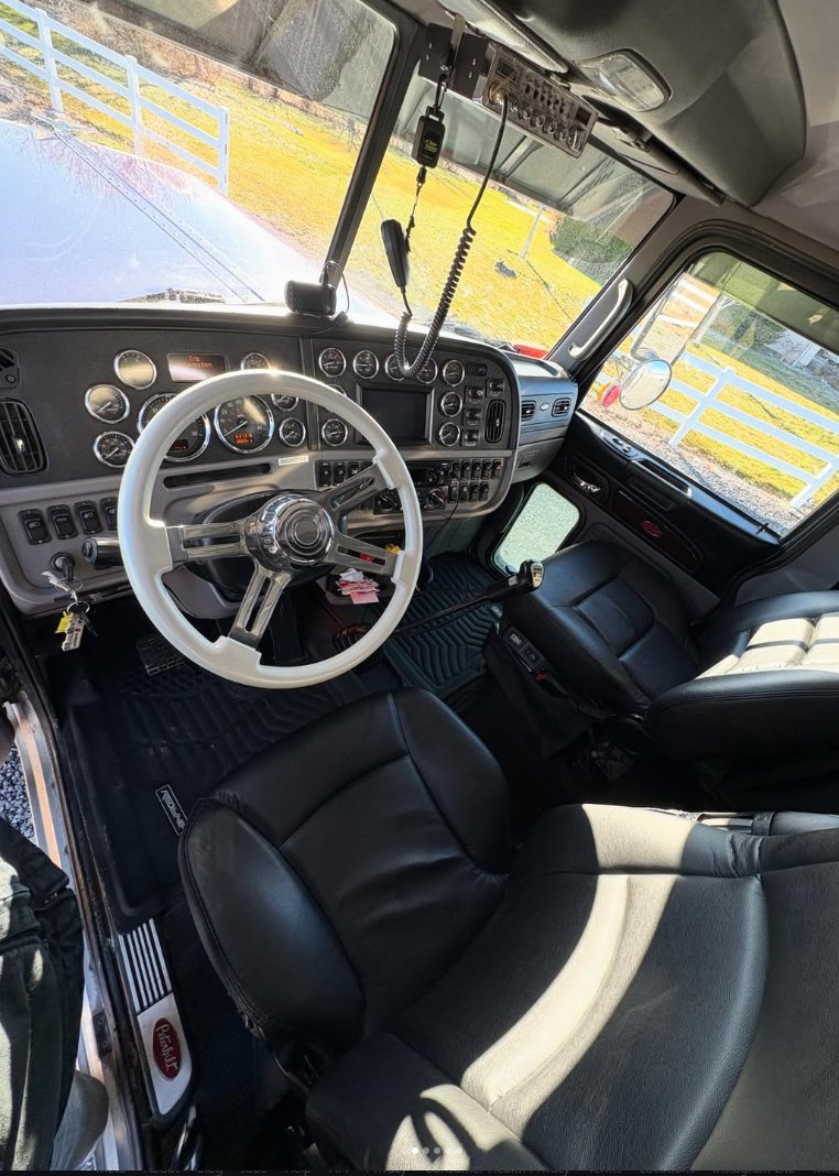 Truck cab interior with a white steering wheel